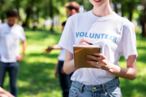 volunteer writing in notebook at outside event